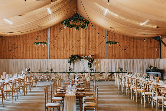 Wedding meal set up with long tables, fairy lights and flowers